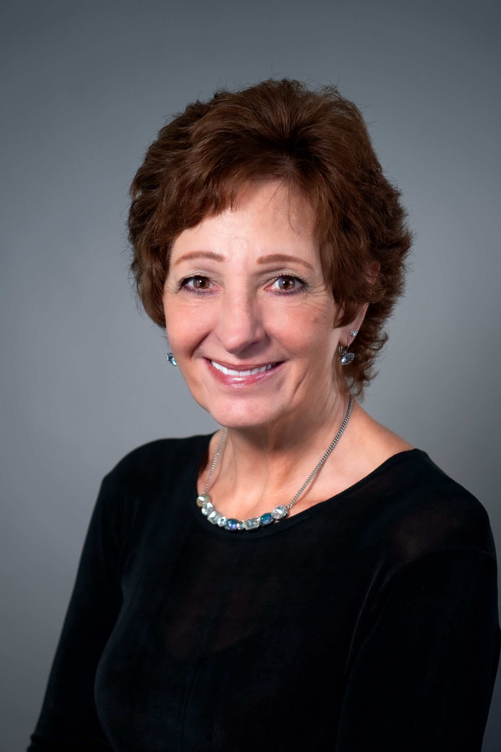 a woman in a black top is smiling