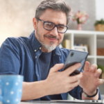 a man sitting at a table looking at a tablet