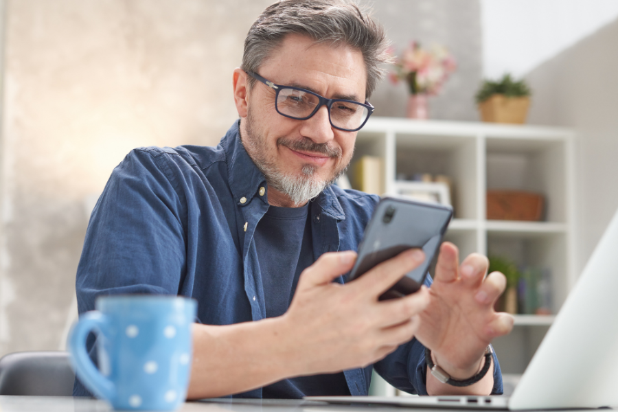 a man sitting at a table looking at a tablet