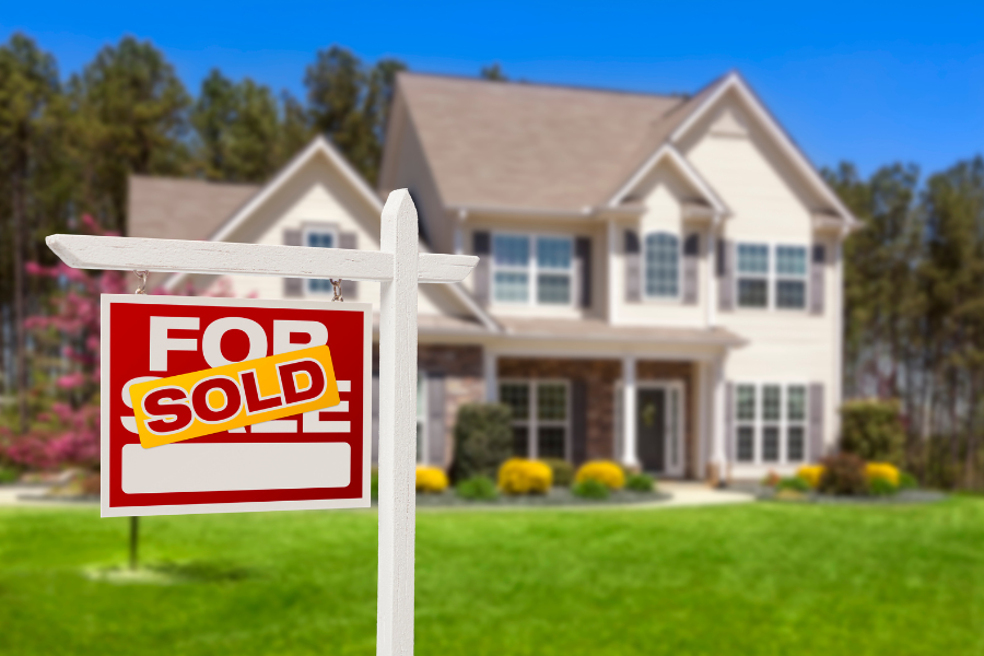 a for sale sign in front of a house