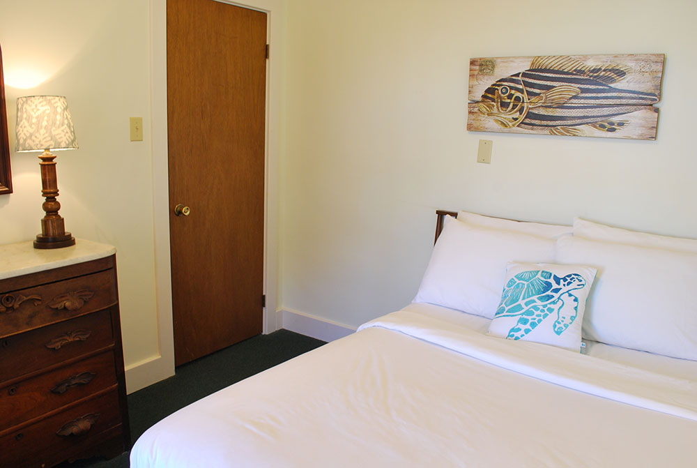 a bedroom with a bed, dresser and mirror