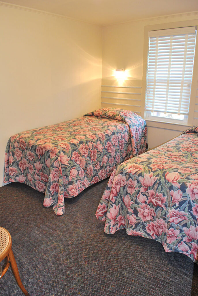 two beds in a room with floral bedspreads