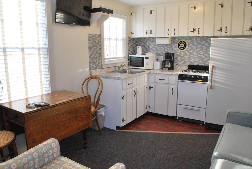 a kitchen with white cabinets and appliances in it