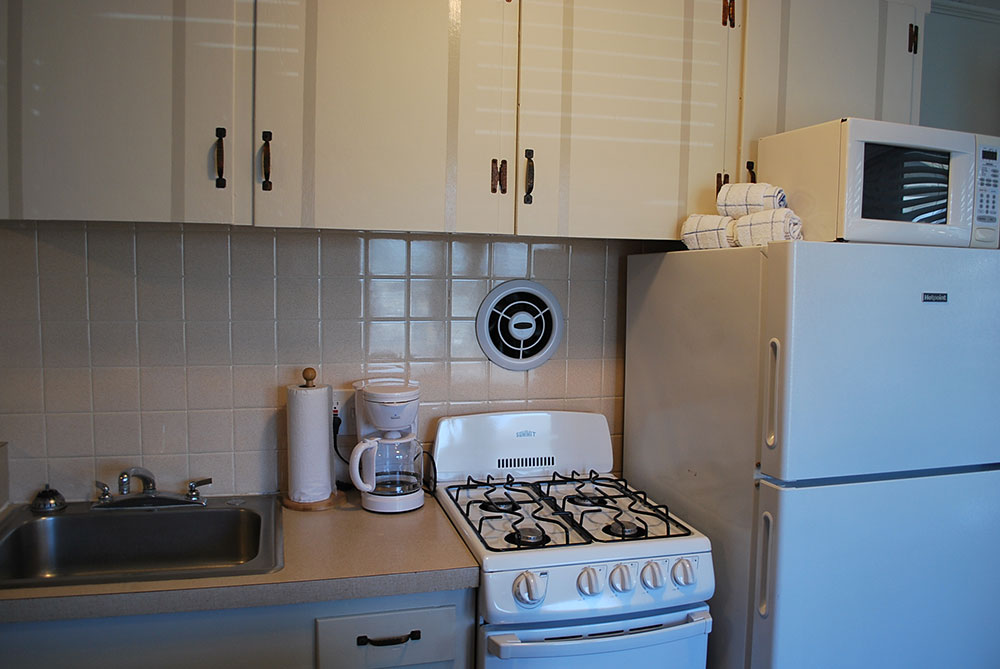 a white stove top oven sitting inside of a kitchen