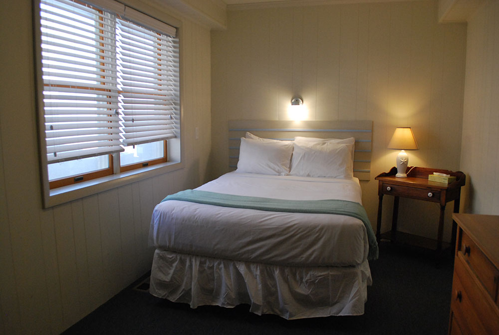 a bed sitting in a bedroom next to a window
