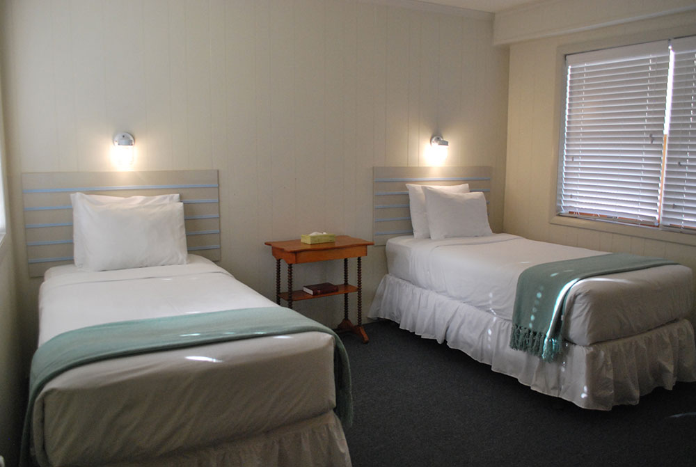 two twin beds in a hotel room with white walls