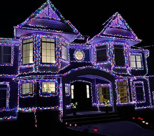 a large house covered in christmas lights at night