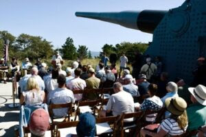 a group of people sitting in front of a large airplane