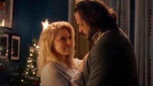 a man and a woman standing in front of a christmas tree