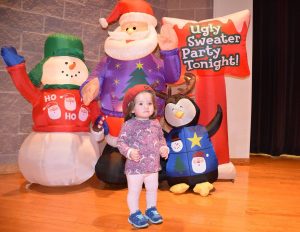 kid in front of holiday blow up santa