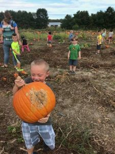 kid holding pumpkin