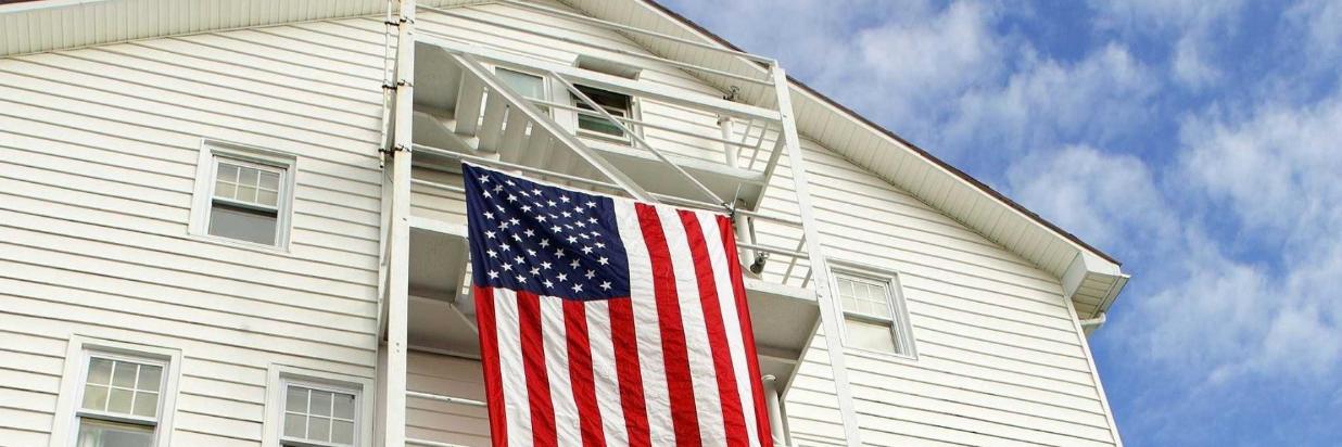 american flag hanging from stairs on exterior of apartment