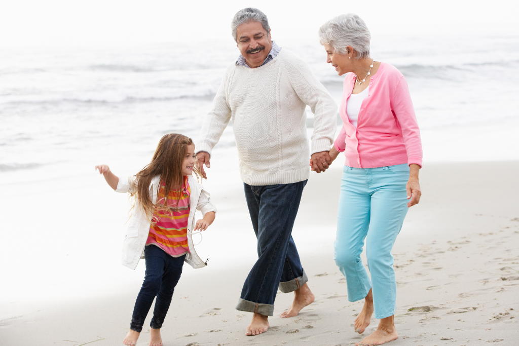Grandparents and young girl on beach