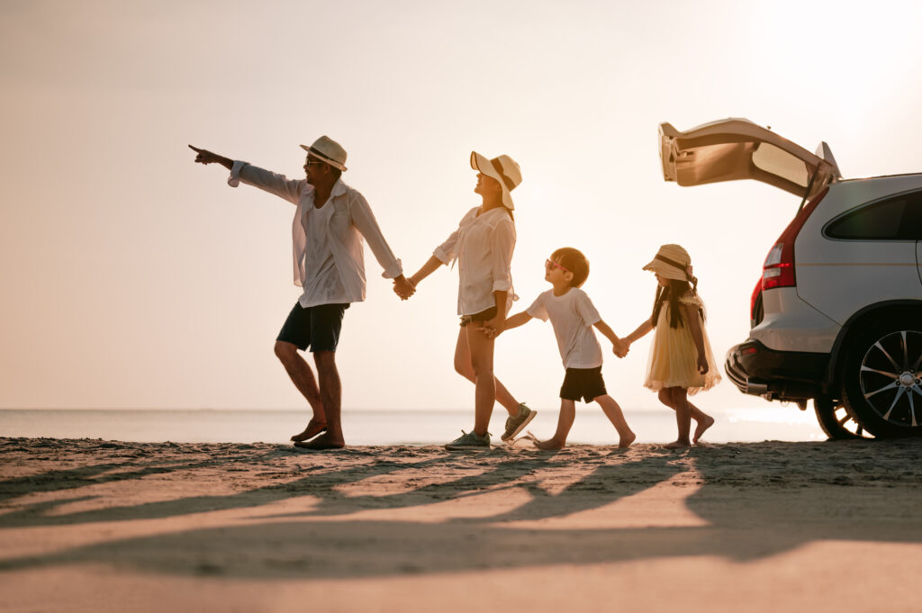Family walking from their car to the beach