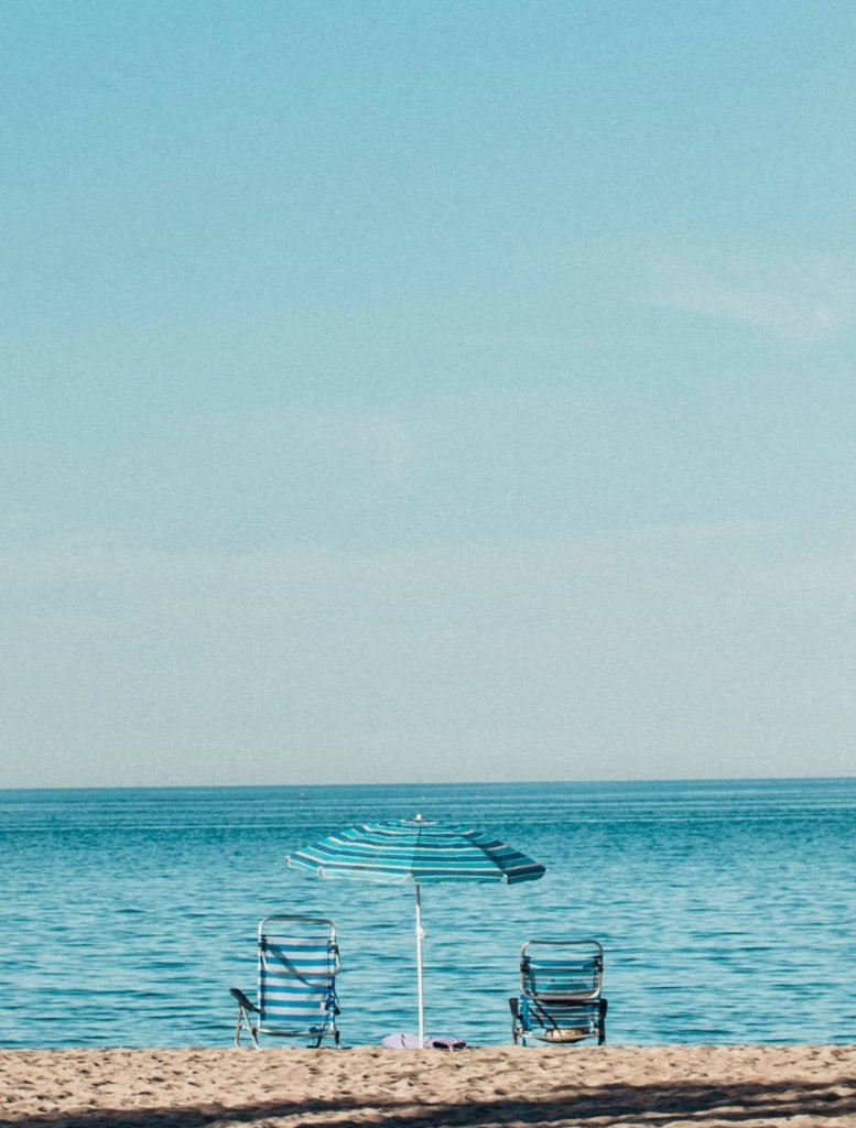 two beach chairs and umbrella oceanfront