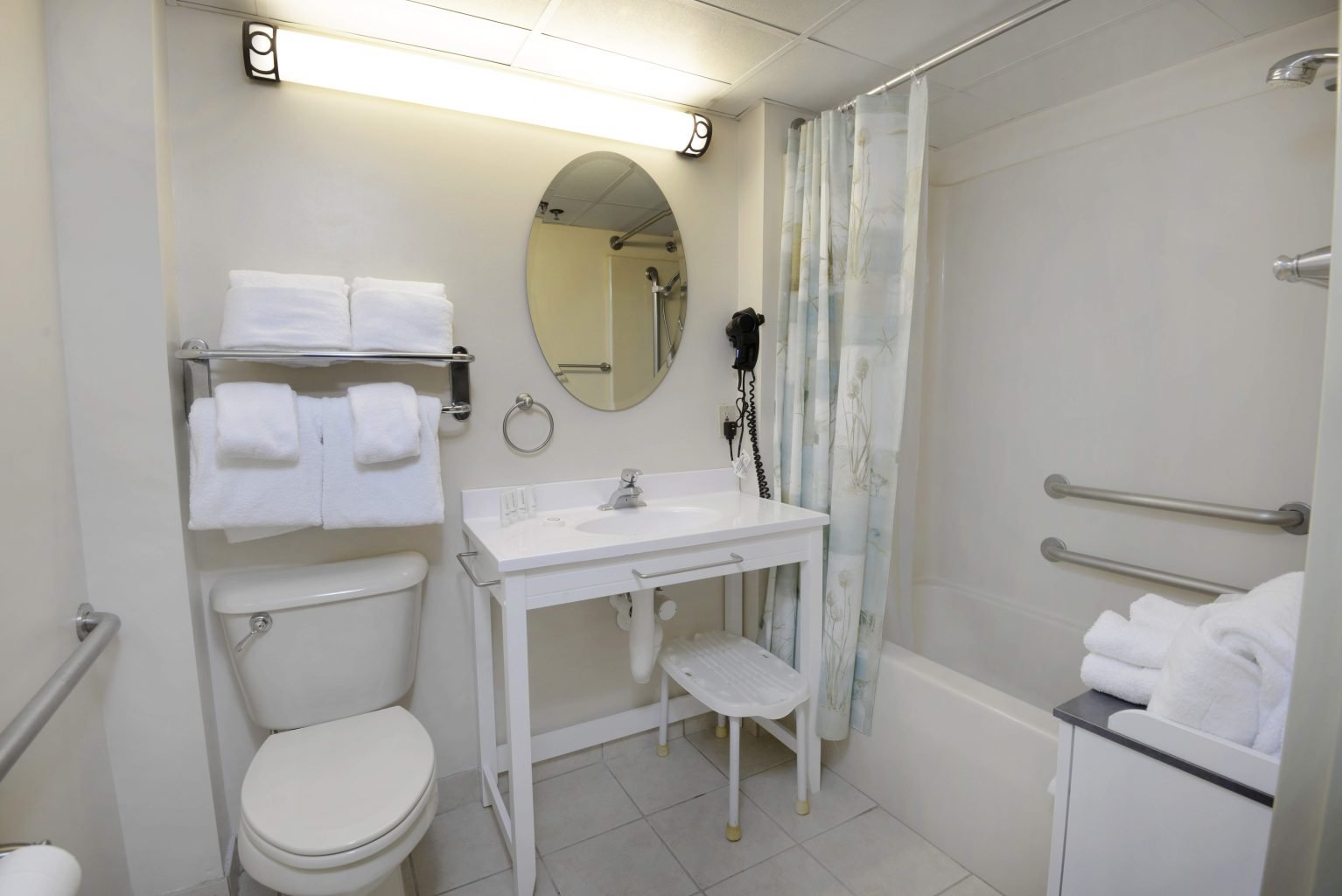 a clean bathroom with a toilet, sink, bathtub, and towels
