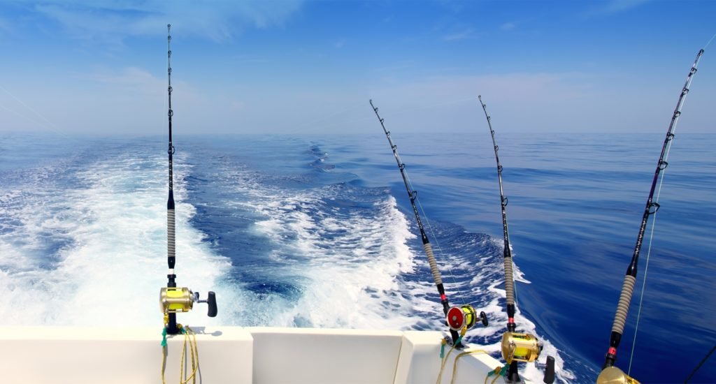 fishing rods hanging off fishing boat on the water