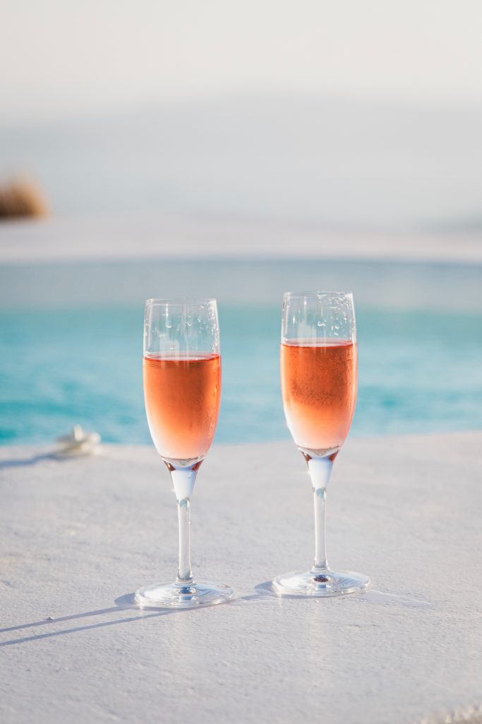 two champagne glasses by pool