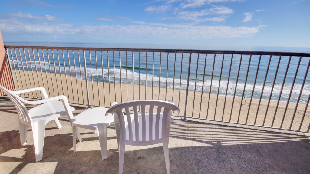 oceanfront view from deck with chairs and table