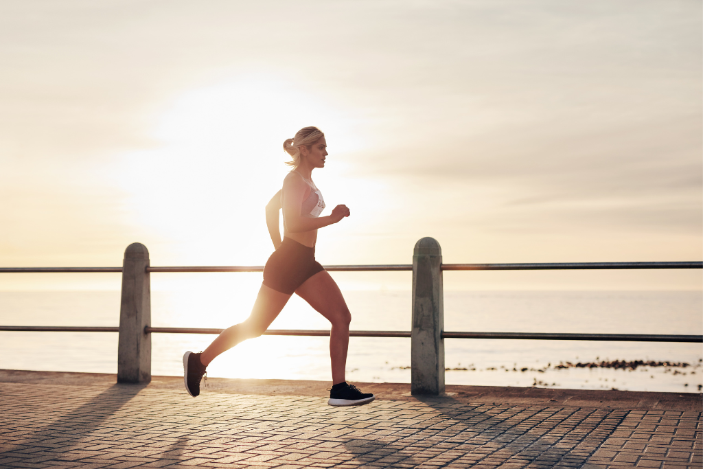 woman running along ocean pathway