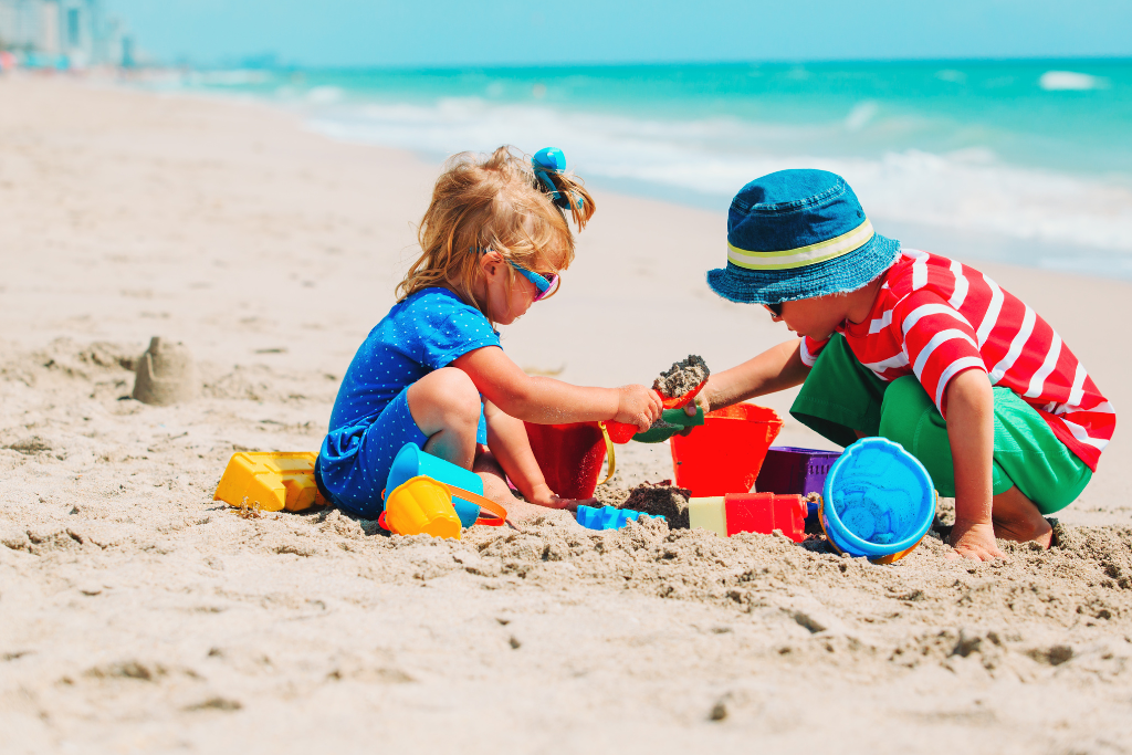 two children playing in sand on the beach