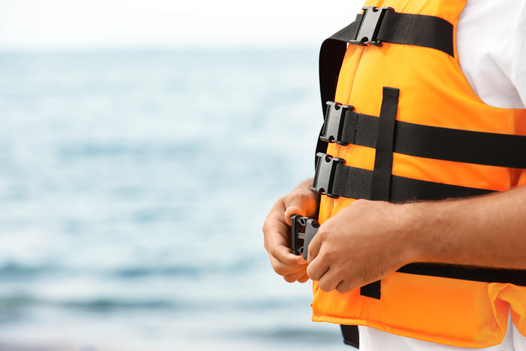 person wearing life vest by ocean
