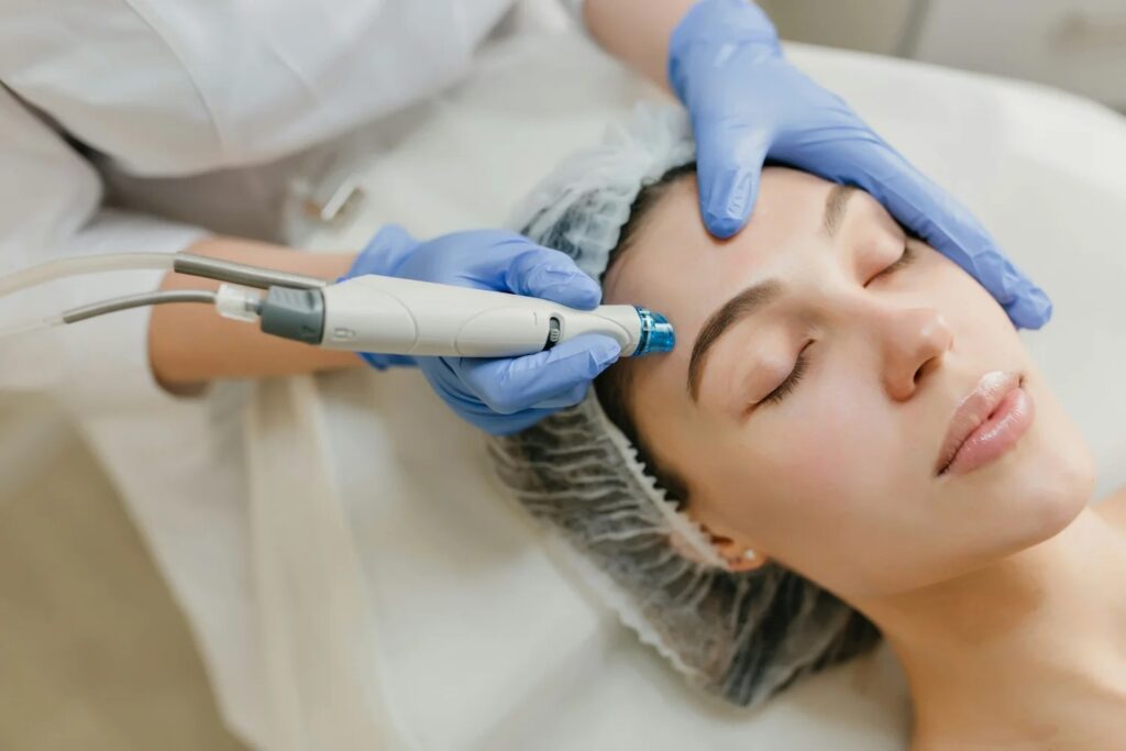 A woman receiving a facial treatment with a device.