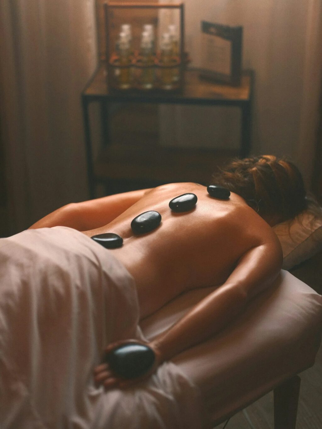 A person receiving a stone massage on a table