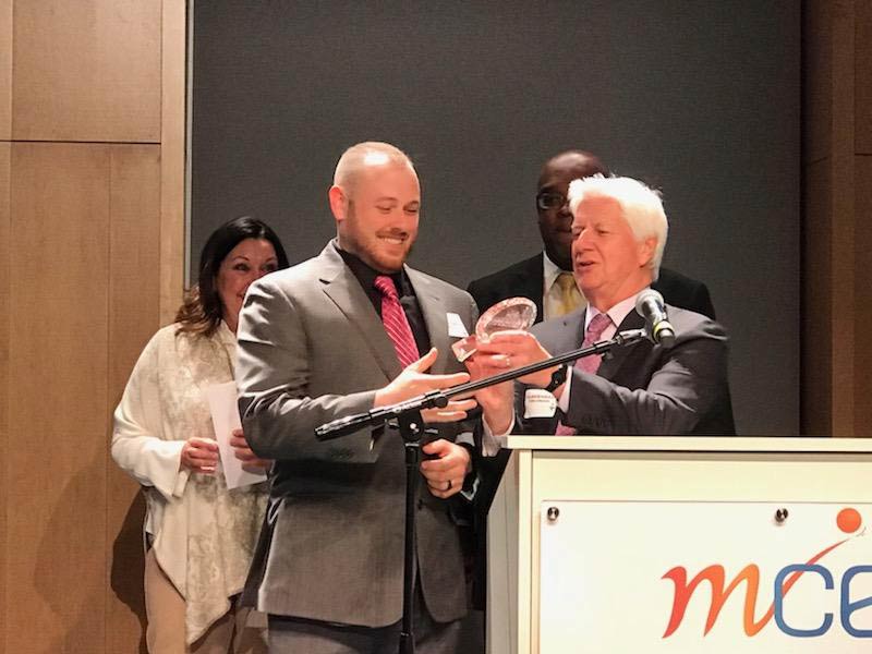 2018 entrepreneur of the year receiving award at podium