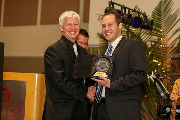 2013 entrepreneur of the year accepting award and posing with official