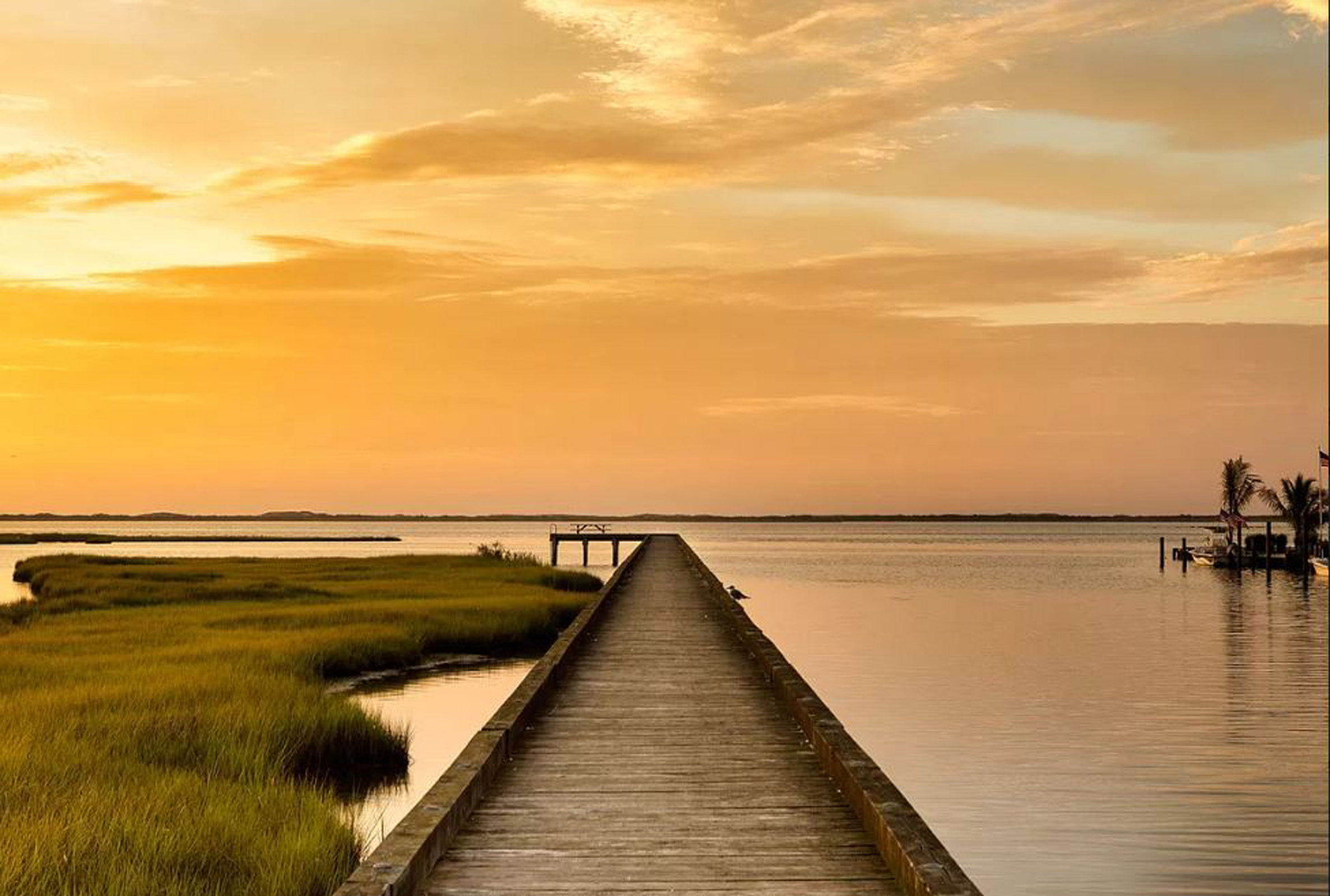 sunset on the bay with a dock.