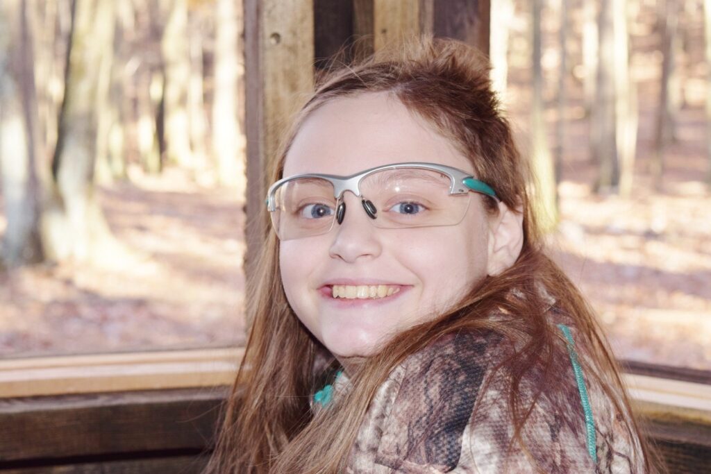 a girl with glasses sitting in a train
