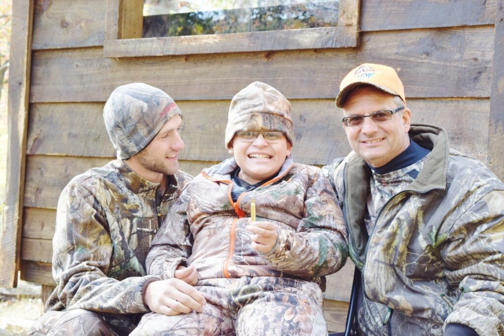 two men and a child sitting on the ground