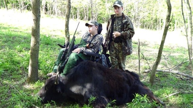 a couple of men standing next to a cow