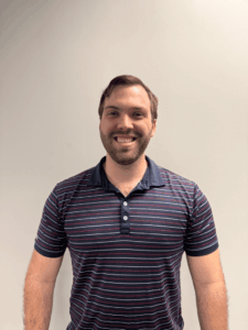 a man standing in front of a white wall