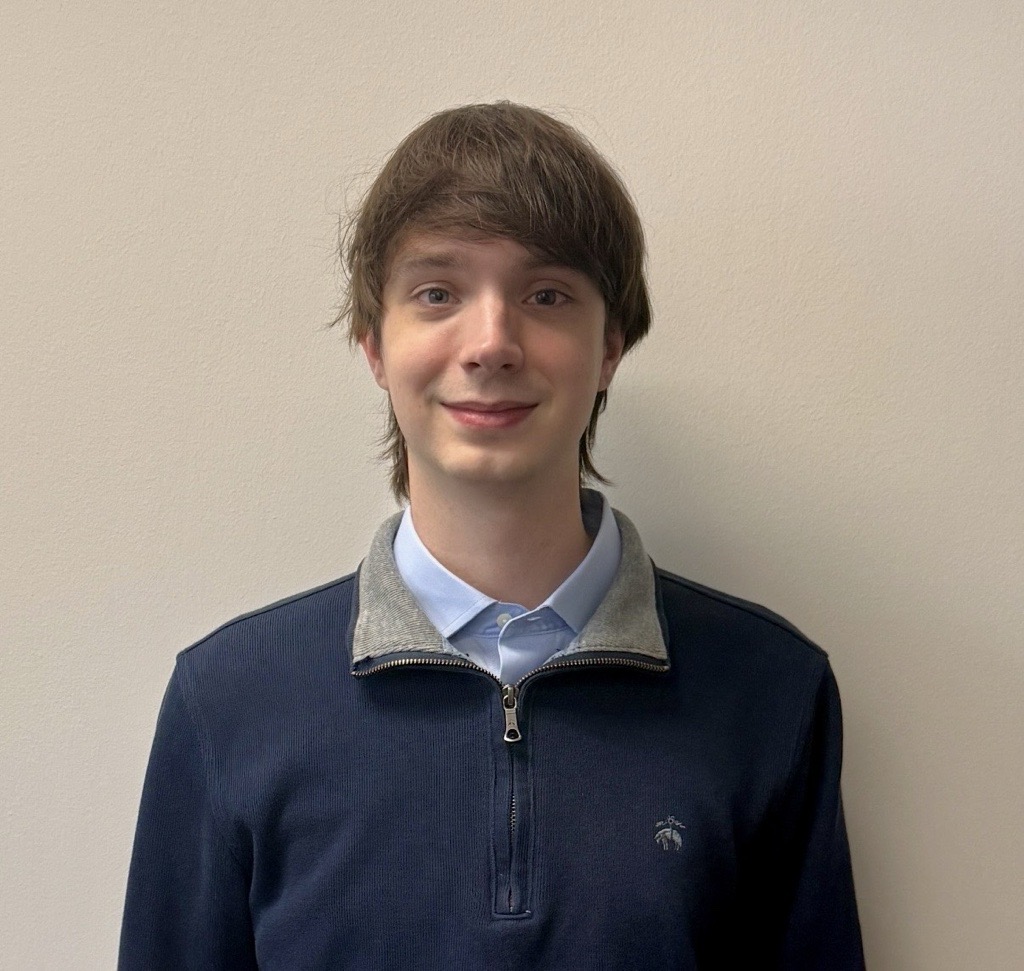 a young man standing in front of a wall
