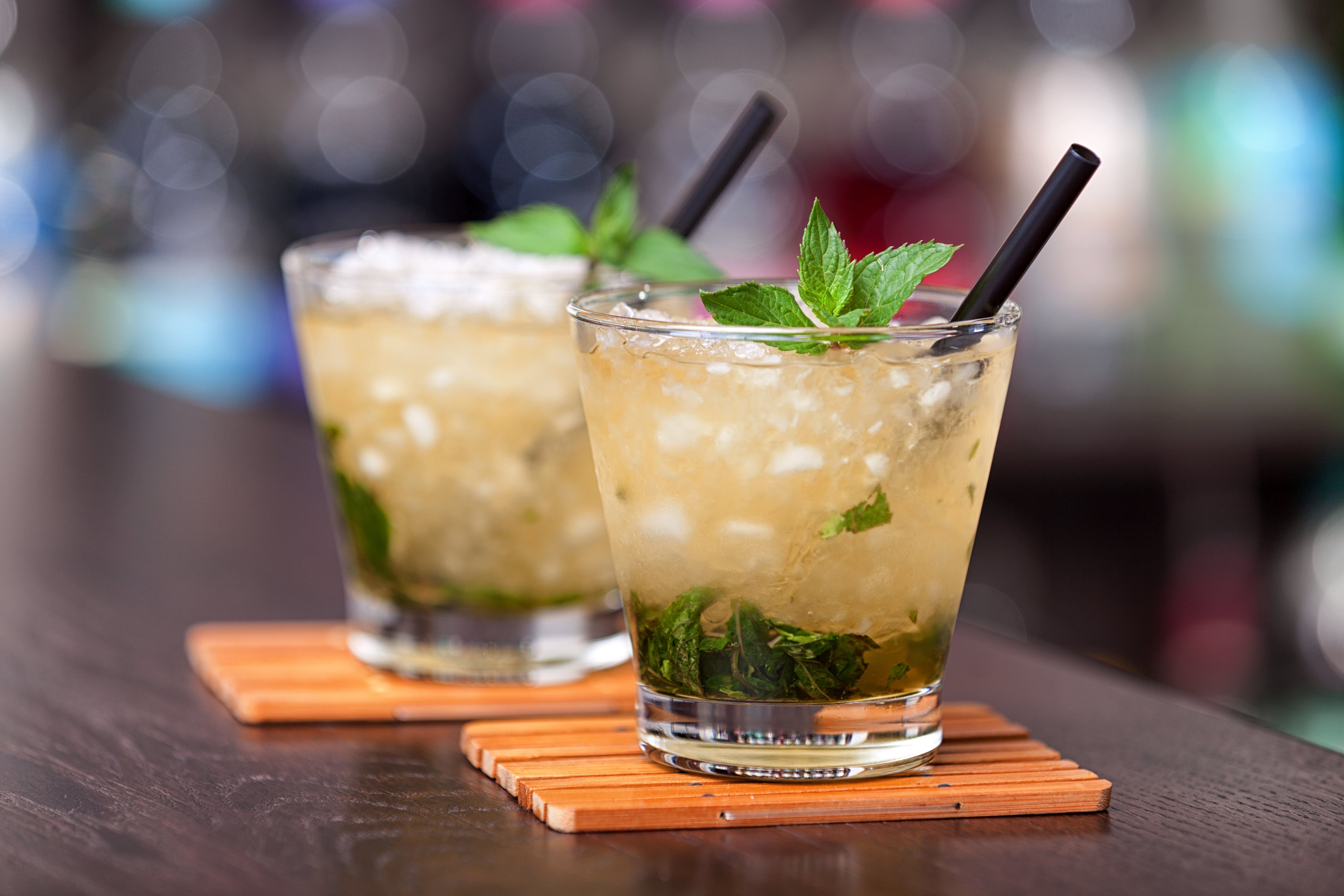 Two mint juleps on wood coasters