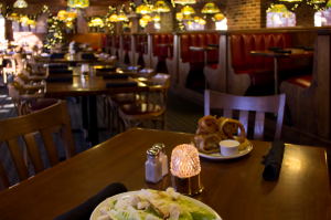 restaurant dinner table with plate of onion rings and salad on plate