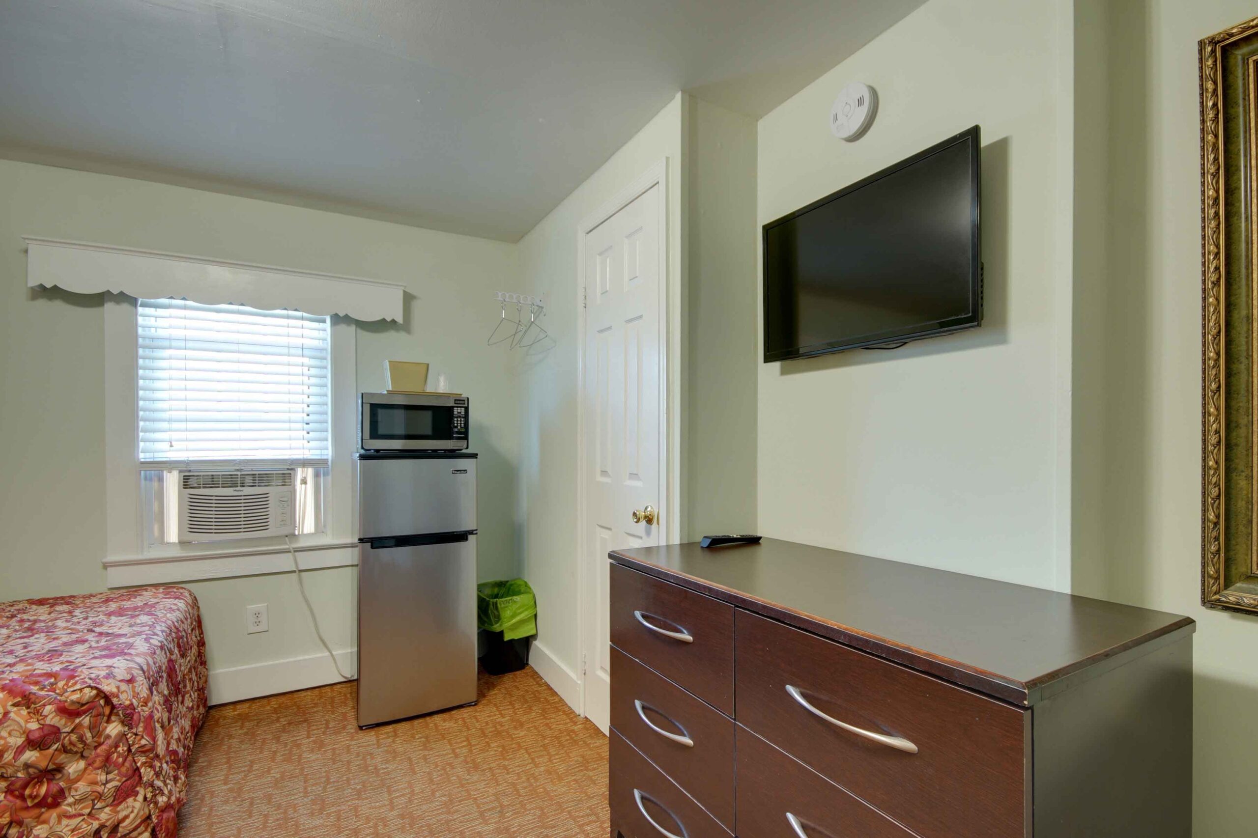hotel room with fridge and tv