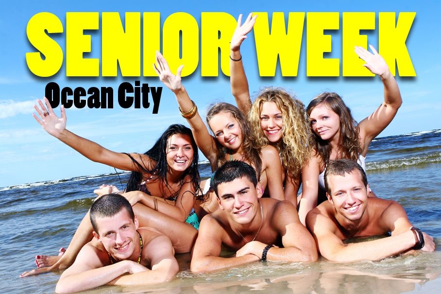 group of high school grads laying in the surf posing, smiling, and waving