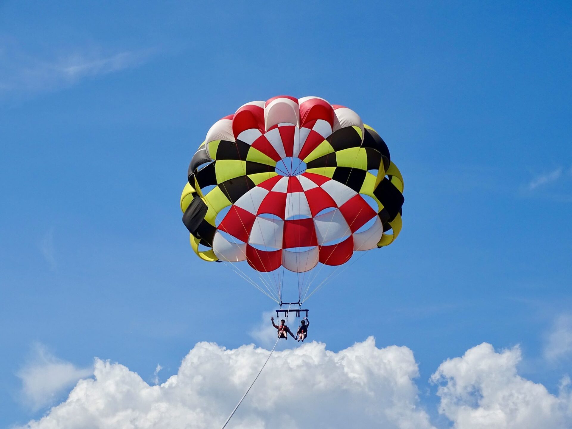 couple parasailing in Ocean City, MD with a MD flag parachute