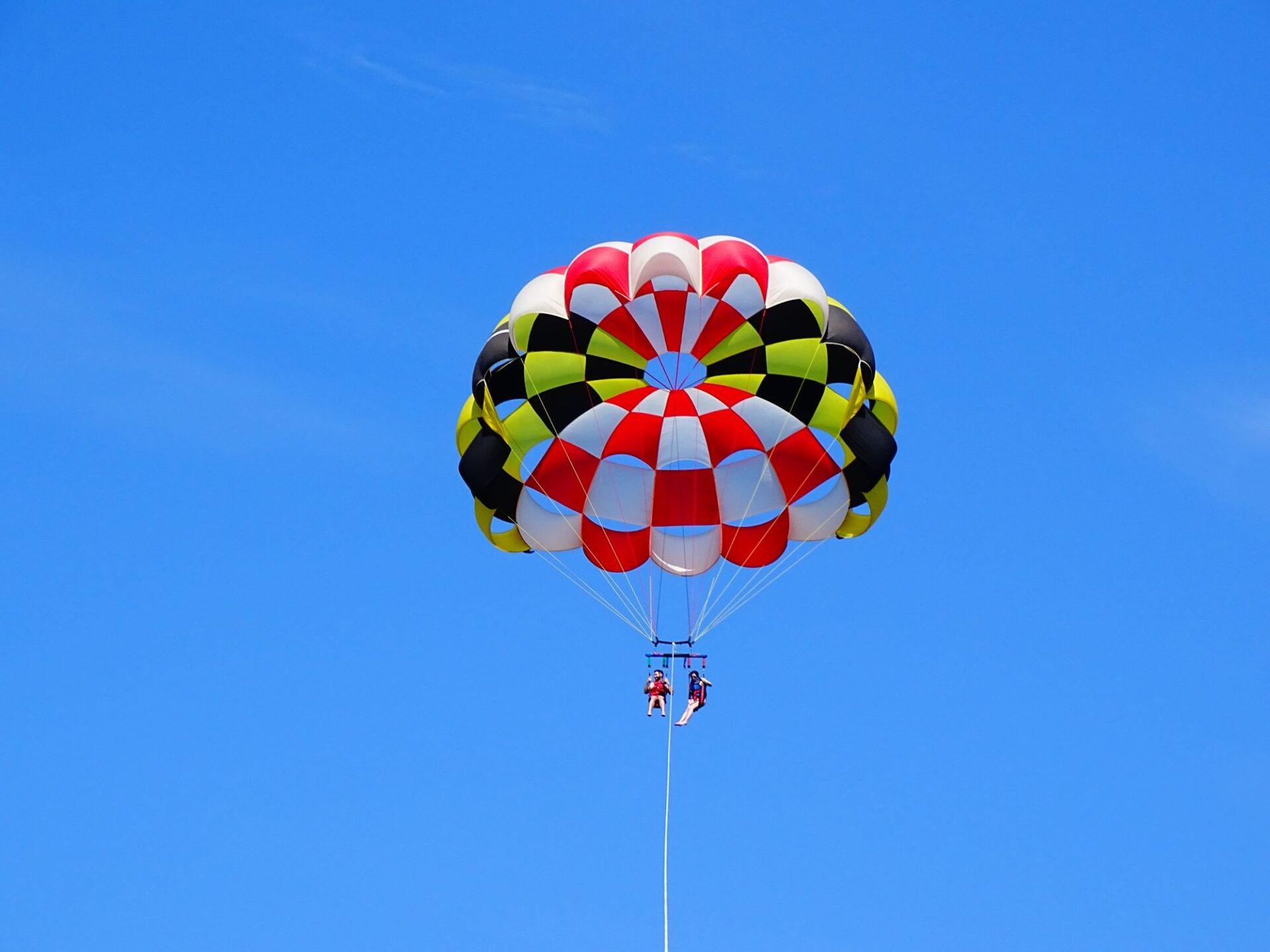 couple parasailing in Ocean City, MD with a MD flag parachute