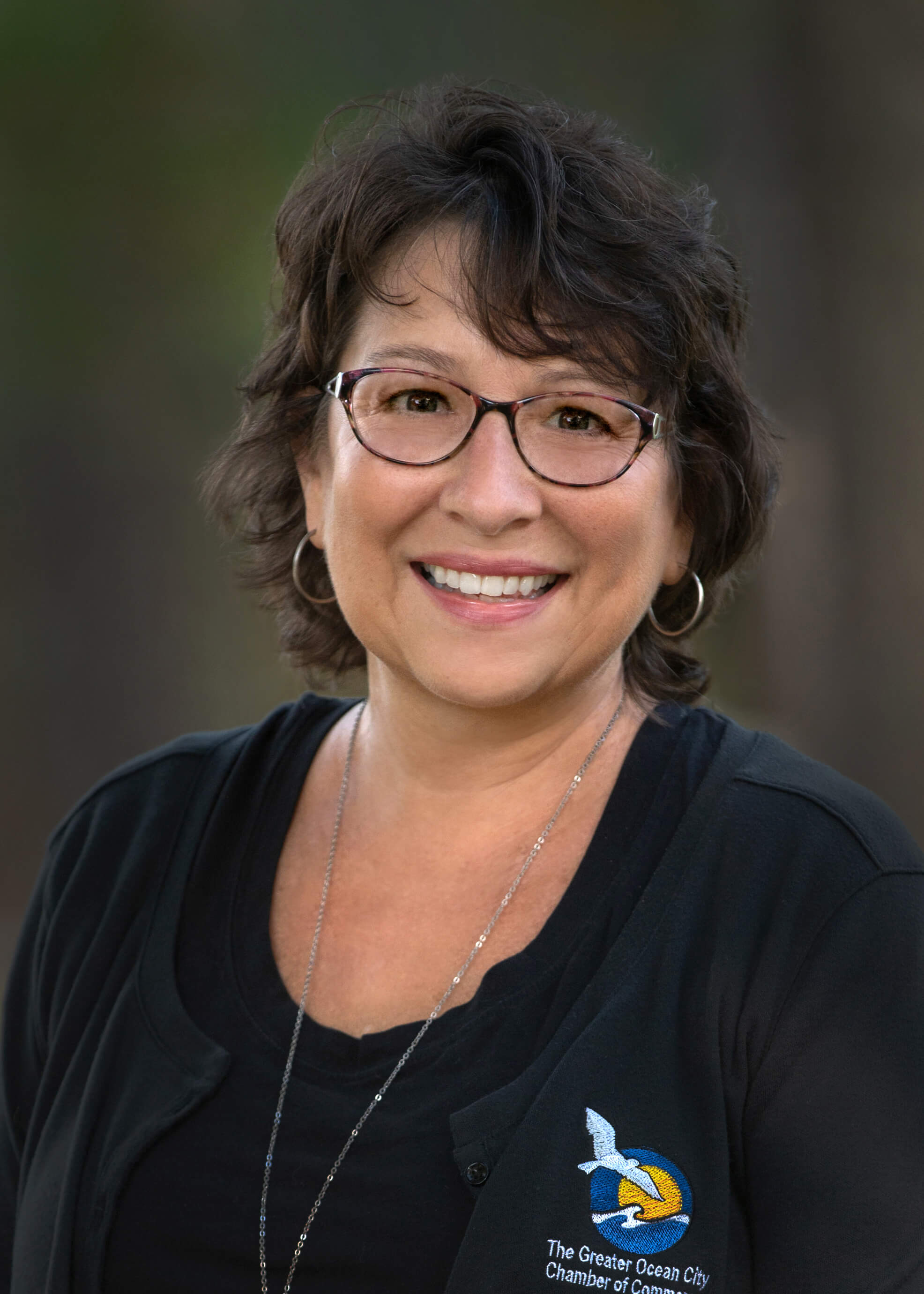 a woman with glasses smiling for the camera