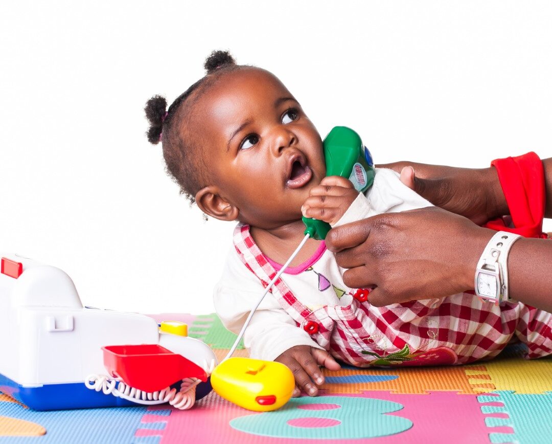 toddler girl answering a play phone