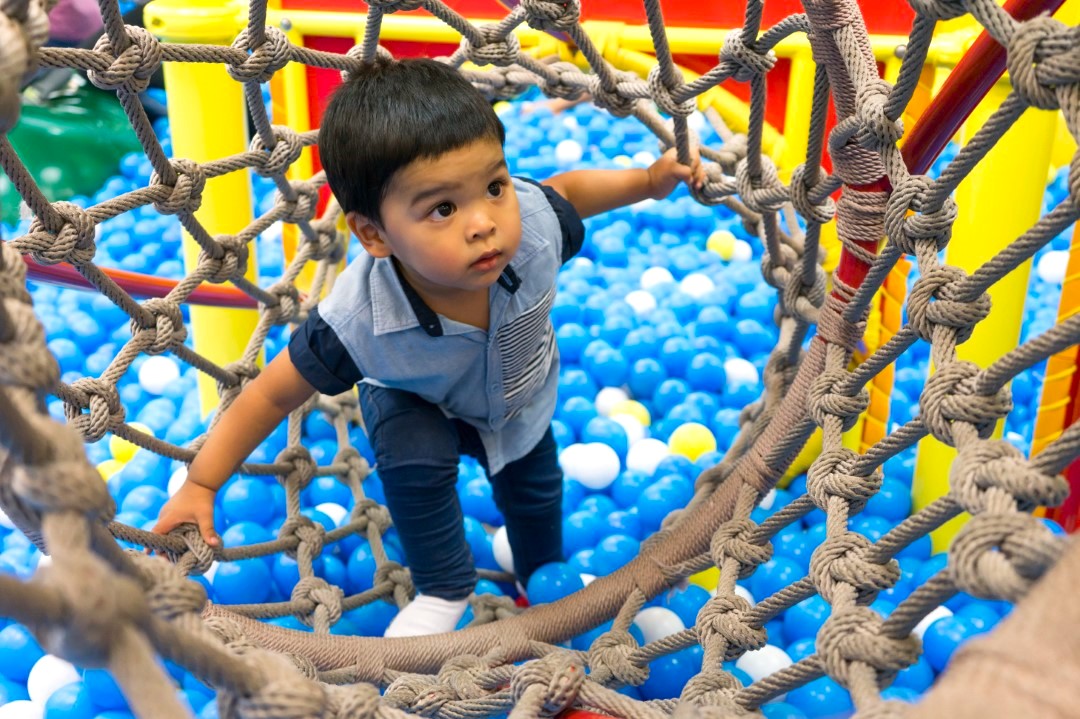 little boy playing inside a tunnel in the playground