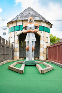 a miniature golf course with a statue of a man holding a woman