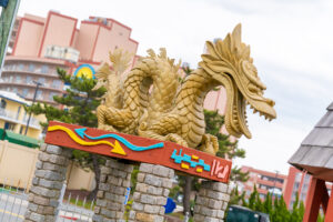 a statue of a dragon on top of a brick wall
