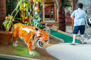 a fake tiger and a zebra on a miniature golf course