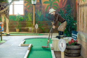 a miniature golf course with a giraffe statue