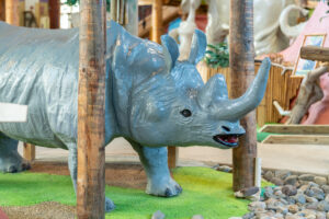 a statue of a rhinoceros in a play area